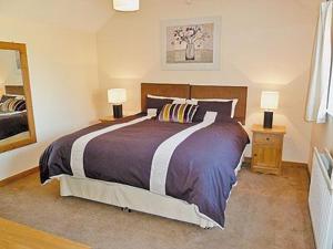 A bed or beds in a room at Milliners Barn 