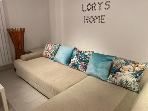a couch with pillows on it in a living room at Bari Lory’s Home in Bari