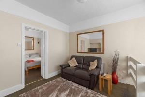ein Wohnzimmer mit einem Sofa und einem Spiegel in der Unterkunft Amherst Lodge. in Plymouth