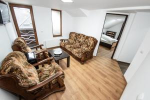 ein Wohnzimmer mit 2 Stühlen und einem Sofa in der Unterkunft Casa Câmpulungeană in Câmpulung Moldovenesc
