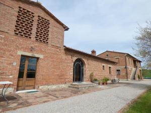 ceglany budynek z drzwiami na boku w obiekcie Agriturismo San Fabio w mieście Castelnuovo Berardenga