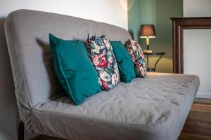 a gray couch with pillows on it in a room at T2 3 étoiles de charme 40 m2 centre ville Dax in Dax