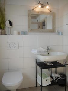 Baño blanco con lavabo y espejo en Ferienhaus Oceanview en Sierksdorf