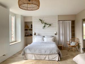 um quarto com uma cama branca e uma cadeira em Tuilerie de Talouan Maison de maître 4 étoiles écologique et tout confort em Villeneuve-sur-Yonne