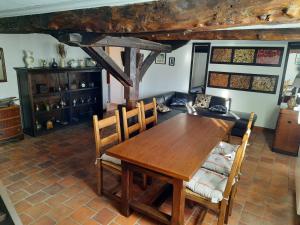 a dining room with a wooden table and chairs at La ferme aux Perdrix in Beuvron-en-Auge