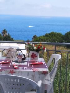 een witte tafel en stoelen met uitzicht op de oceaan bij Ponzamania Appartamenti ,,Belvedere'' Ponza in Ponza