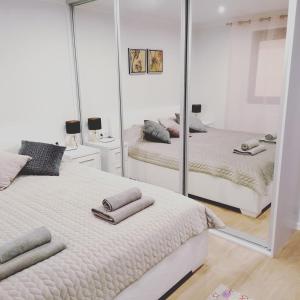a bedroom with two beds and a large mirror at Zemzari in Jūrkalne