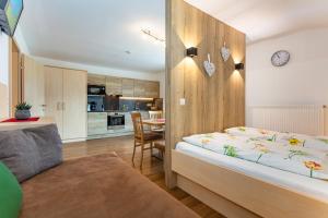 a bedroom with a large bed and a kitchen at Biobauernhof Aslgut in Bad Hofgastein