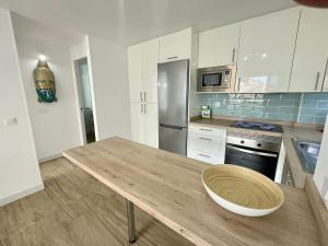 a kitchen with a wooden table and a refrigerator at Style & Sea FREEWIFI in Los Cristianos