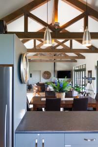 a kitchen and living room with a table and a dining room at Orokawa Bay Retreat in Waihi