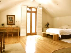 a bedroom with a bed and a desk and a window at The Loft in Johannesburg