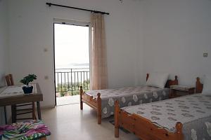 a bedroom with two beds and a large window at Sea La Vie Apartment Koroni in Koroni