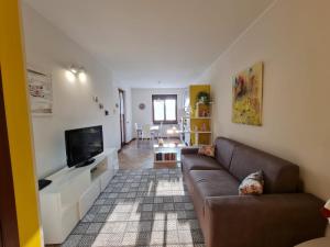 uma sala de estar com um sofá e uma televisão de ecrã plano em Francesca's home em Bardolino