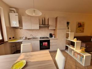 uma cozinha e sala de estar com uma mesa e uma cozinha em Francesca's home em Bardolino