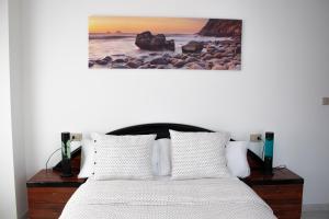 a bedroom with a bed and a painting on the wall at Apartamento Sol do Coído in Muxia