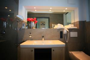 La salle de bains est pourvue d'un lavabo et d'un miroir. dans l'établissement Alte Molke Apartment 2, à Meersburg
