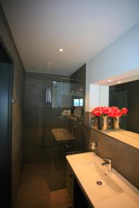 een badkamer met een wastafel, een spiegel en rode rozen bij Alte Molke Apartment 10 in Meersburg