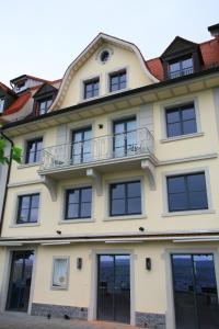 een geel gebouw met ramen en een balkon bij Alte Molke Apartment 10 in Meersburg