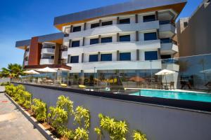 a building with a swimming pool and a resort at Hotel da Costa By Nobile in Aracaju