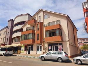 a building with two cars parked in front of it at Happy House in Năvodari