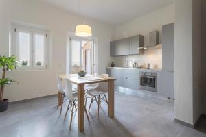 a kitchen with a wooden table and white chairs at Appartamento Casa Nina in San Miniato