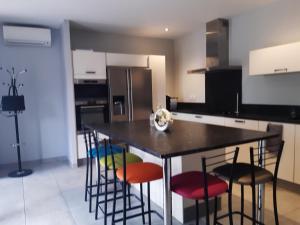 a kitchen with a table with chairs and a refrigerator at Domaine Fontgrande Gîte in Carcassonne