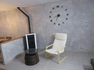 a room with a chair and a clock on the wall at Marta's house in Prebernardo