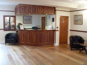 uma sala de espera com uma caixa registadora e cadeiras em Merlewood Hotel em Saundersfoot