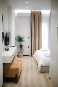 Schlafzimmer mit einem Bett, einem Waschbecken und einem Spiegel in der Unterkunft Boulevard Boutique Aparthotel in Korçë