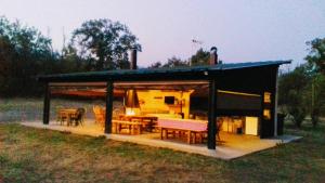 a shed with a table and chairs in a field at El Paso de las Cigüeñas in Candeleda