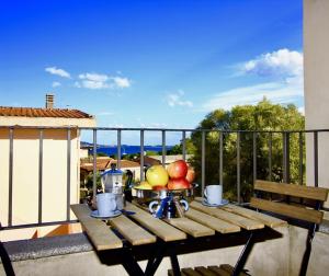 un tavolo con un cesto di frutta sul balcone di Fenile Apartments a Santa Maria Navarrese