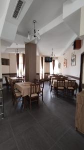 a dining room with tables and chairs and a tv at Стаи за гости ВЕНИ-ЕВ in Devin