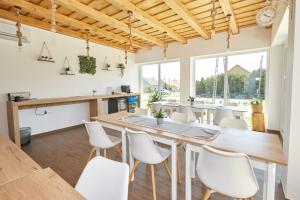 a dining room with a large wooden table and white chairs at Naturella Panzió in Villány