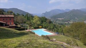 ein Schwimmbad auf einem Hügel mit Bergen im Hintergrund in der Unterkunft Garda Lake Dana Home in Salò
