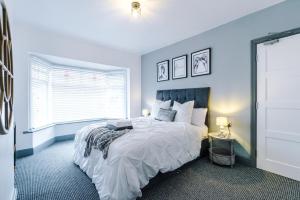 een slaapkamer met een groot bed en een raam bij Only Family Groups - Pets Stay for Free - Sleeps 8 - Sofabed in Blackpool