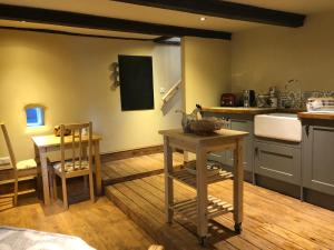a kitchen with a counter and a table and a sink at Lane House Farm in Todmorden