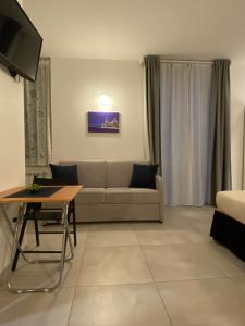 uma sala de estar com um sofá e uma mesa em Alba rooms em La Spezia