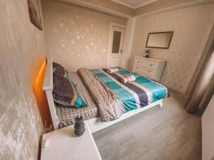 a small bedroom with a bed and a dresser at Luxury Sky Apartment in Chişinău