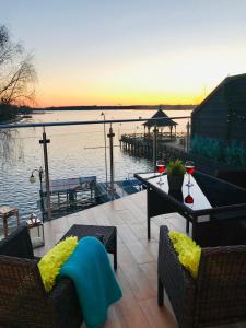 a patio with chairs and a table with a view of the water at Apartament MoLoo II in Ostróda