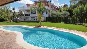 - une piscine en face d'une maison dans l'établissement Alojamiento Rural Las Acacias, à Cabra