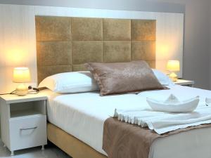 a bedroom with a large white bed with two lamps at DREAM APARTMENTS Saranda in Sarandë +134 photos