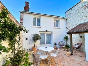 a patio with a table and chairs in front of a house at Au Canon - Parking gratuit - Bords de Loire in Orléans