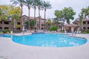 una piscina con palmeras y un edificio en Villa Captiva condo, en Scottsdale