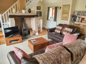 uma sala de estar com um sofá e uma lareira em Little Millend em Coleford