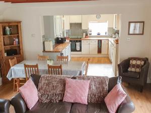 a living room with a couch and a table in a kitchen at Little Millend in Coleford