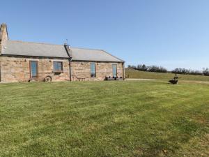 una casa in pietra con un prato davanti di Longstone Cottage a Ugthorpe