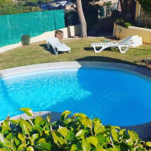 un bambino seduto su una sedia accanto alla piscina di Apartamento Puig Campana a Benidorm