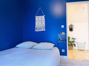 a blue bedroom with a bed with a blue wall at Au Canon - Parking gratuit - Bords de Loire in Orléans