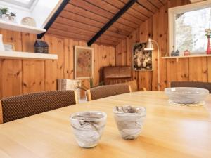 Saltumにある6 person holiday home in Saltumの木製テーブル(上に2杯の鉢をかけたもの)