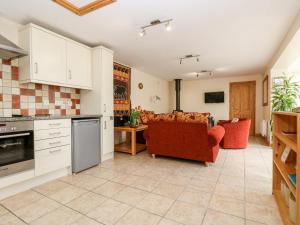a kitchen with white cabinets and a living room at Mynheer Farm Bowji in Redruth
